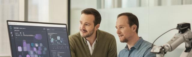 Professional robotics analytics consultants reviewing an operations dashboard in a bright New York office